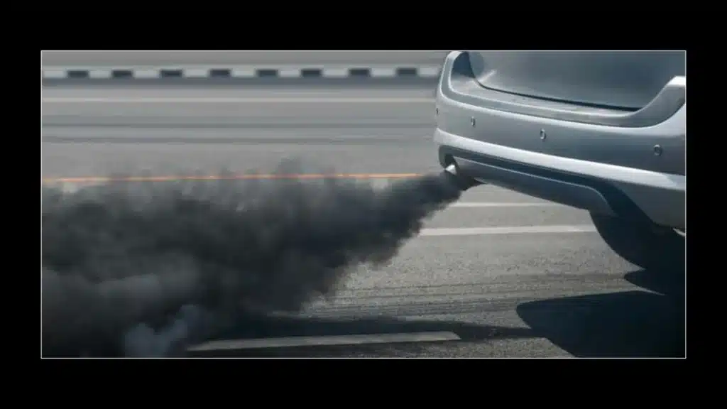 an image of car silencer from whcih a black smoke is coming out