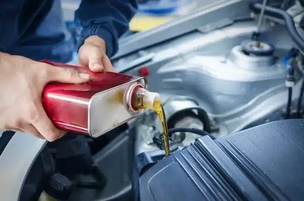 an image of a person pouring mobil oil into a car engine