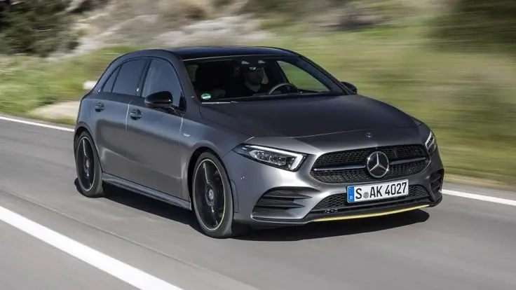 an image of a Mercedes Hatchback black in color and moving a a road 