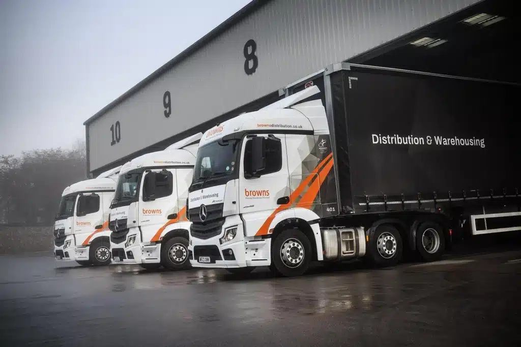 an image showing three white distribution trucks