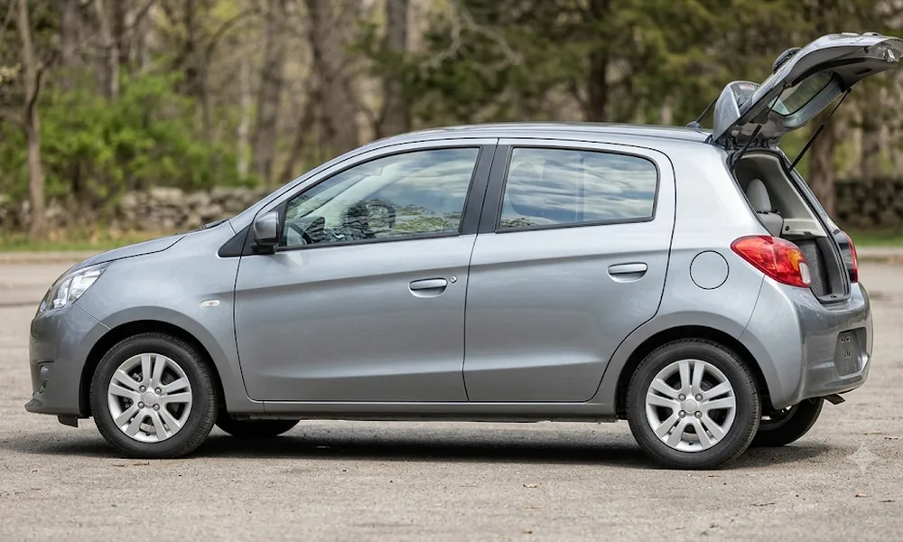 Silver hatchback car parked on a gravel lot with its rear liftgate open