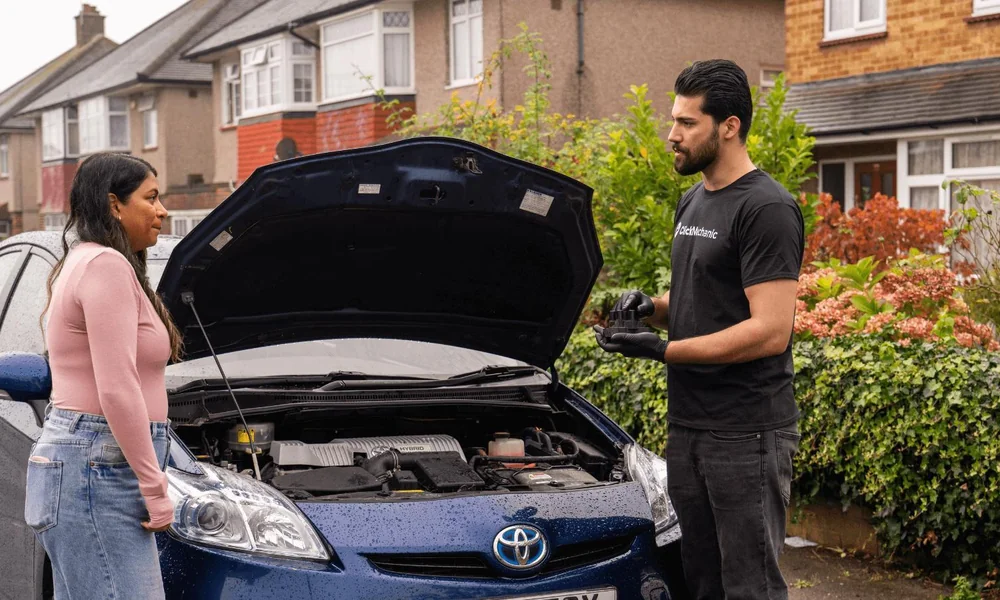 Buyer discussing a used car with its seller beside the vehicle.