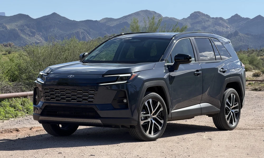 Dark blue Toyota RAV4 parked on a gravel road with mountains behind