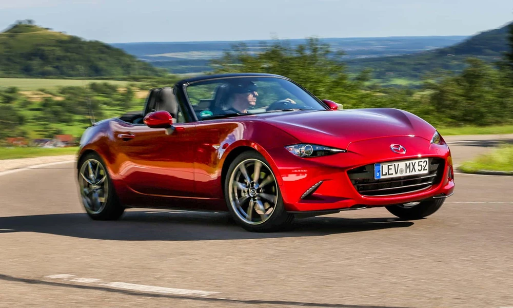 Red Mazda MX-5 Miata convertible on a scenic