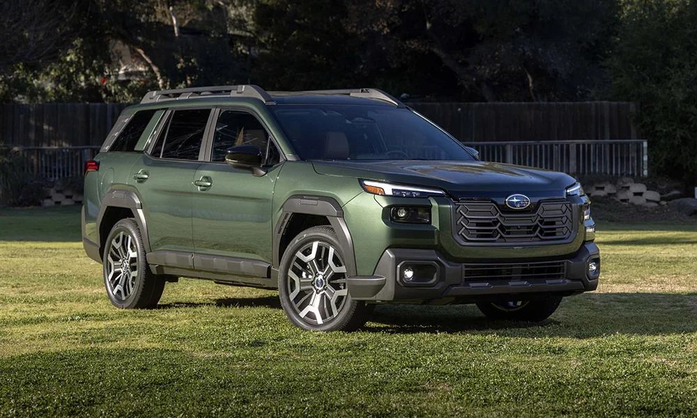 Green Subaru Outback with roof rails parked on a grass lawn