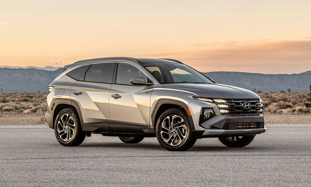 Silver Hyundai Tucson Hybrid on a desert road at sunset