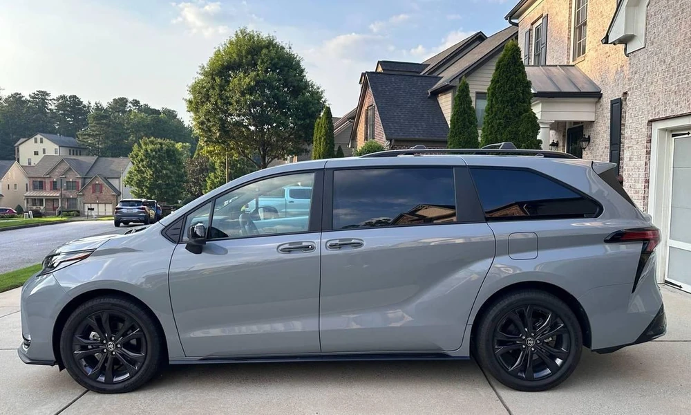Family minivan parked outside a home.