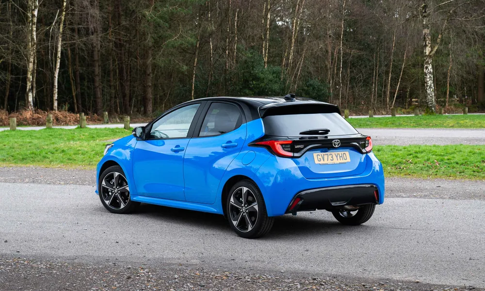 Blue Toyota Yaris hatchback with a black roof, seen from the rear three-quarter angle