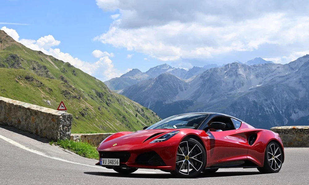 Red sports car parked on a winding mountain road.