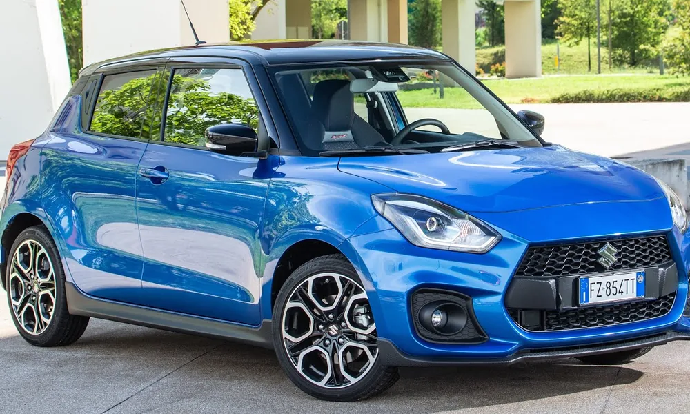 Blue Suzuki Swift hatchback with a black roof and alloy wheels, parked outdoors