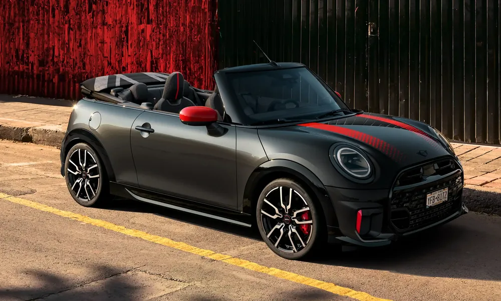 Dark grey MINI Cooper with a red bonnet stripe parked beside a yellow line on the street
