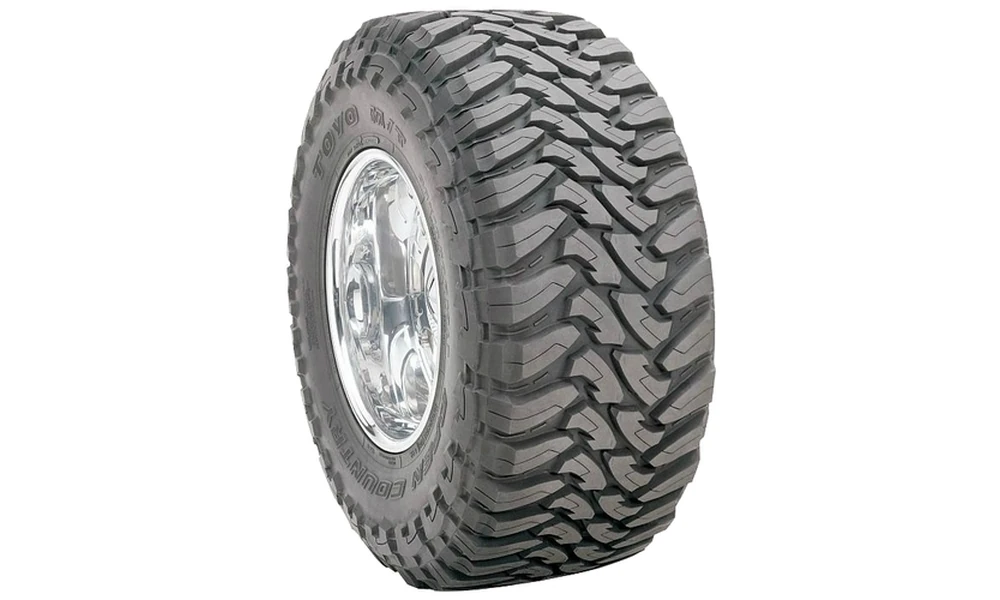 Toyo Open Country M/T mud-terrain tire with deep, wide-spaced tread blocks on a polished chrome wheel