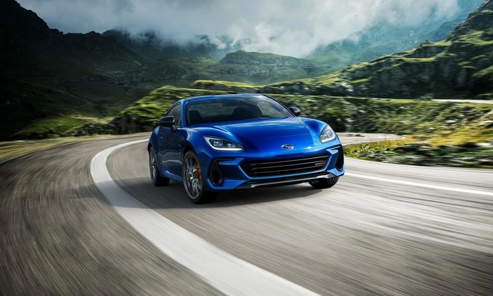 Modern sports coupe parked on a winding mountain road.