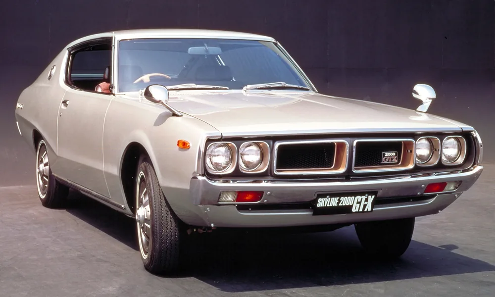 Silver Nissan Skyline 2000 GT-X C110 coupe with four round headlights, chrome bumpers, and classic styling.