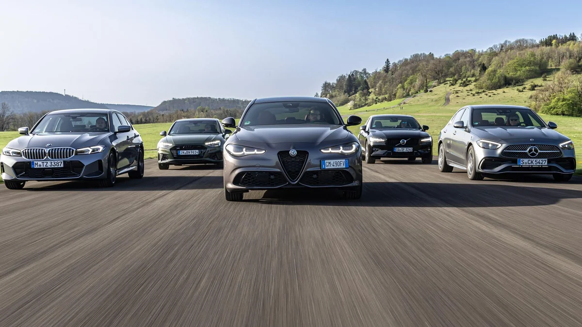 Modern sedan cars parked on a scenic road showing their elegant exterior designs.