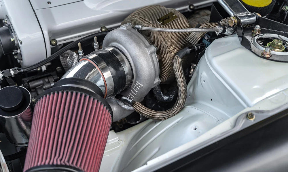 Modified sports car engine bay showing a turbocharger and performance components.