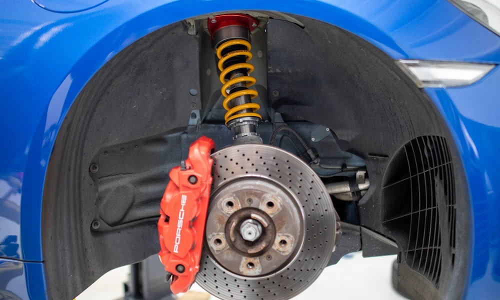 Close-up of a performance car's suspension, brake assembly, and alloy wheel.