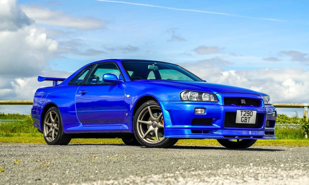 Blue Nissan Skyline GT-R R34 with a large rear spoiler.