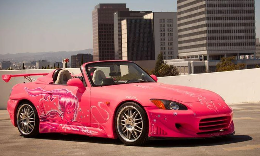 Pink modified Honda S2000 roadster with alloy wheels.