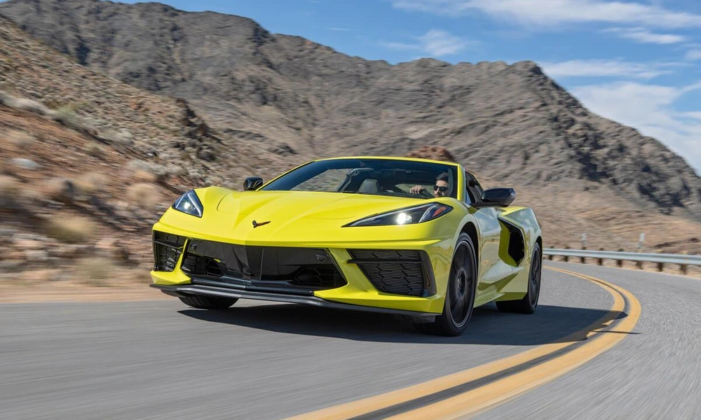 Yellow Chevrolet Corvette Convertible driving on a desert mountain road
