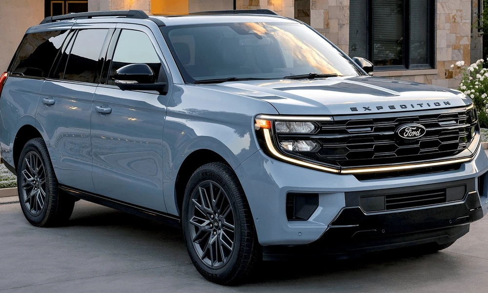 Light blue Ford Expedition with an illuminated front light bar parked outside a stone building