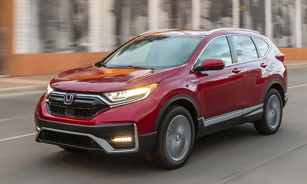A dark red Honda CR-V SUV driving on a city street