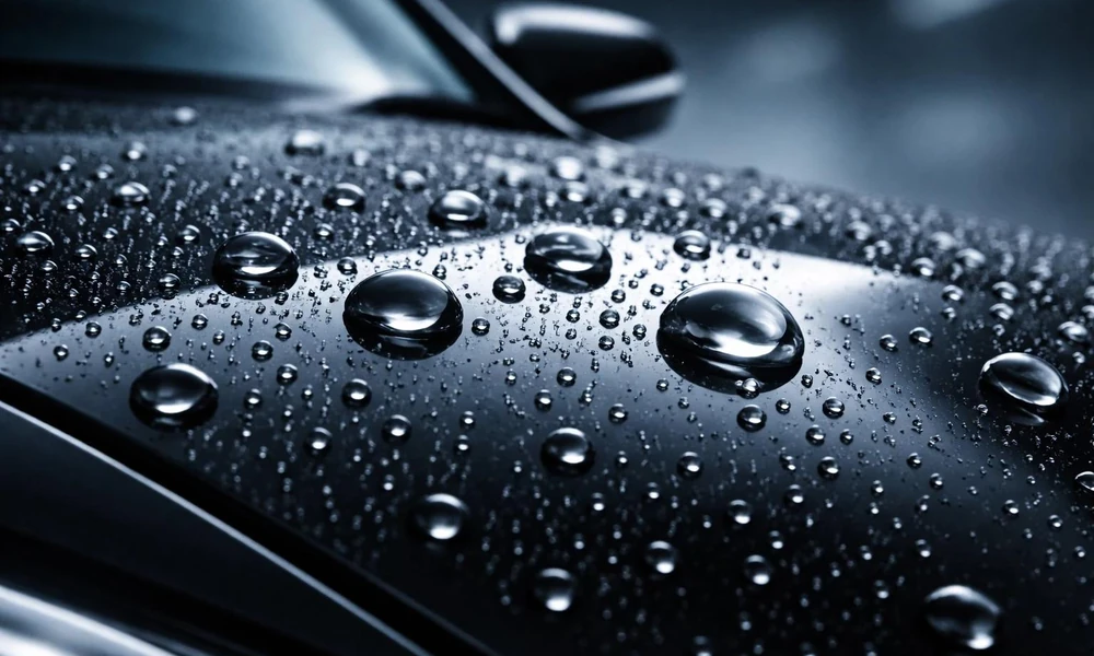 Water droplets beading on a ceramic-coated car hood.