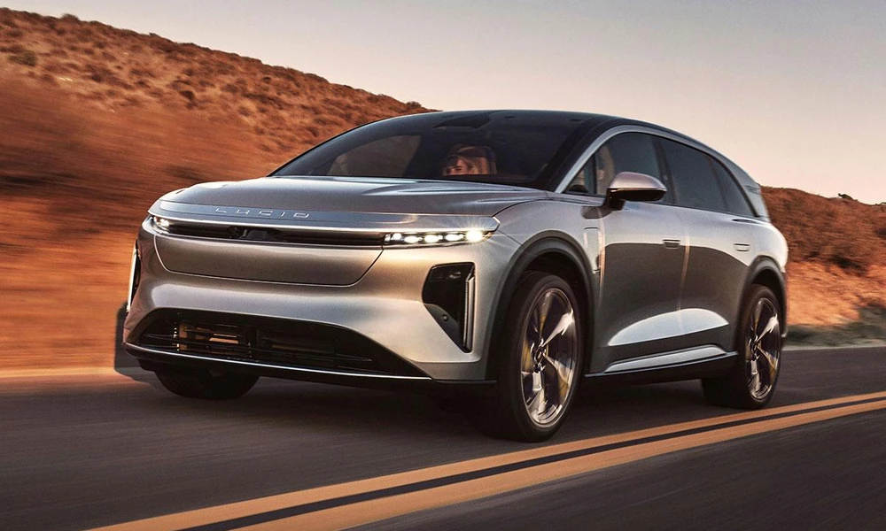 Silver Lucid Gravity electric SUV on a scenic road.