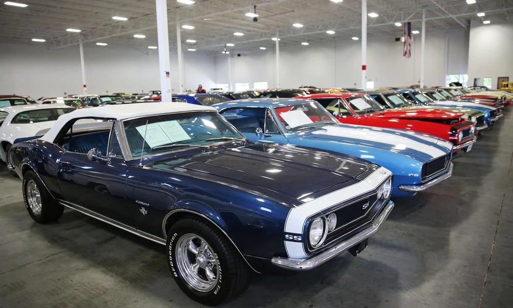 Vintage American muscle cars displayed in a classic-car showroom.