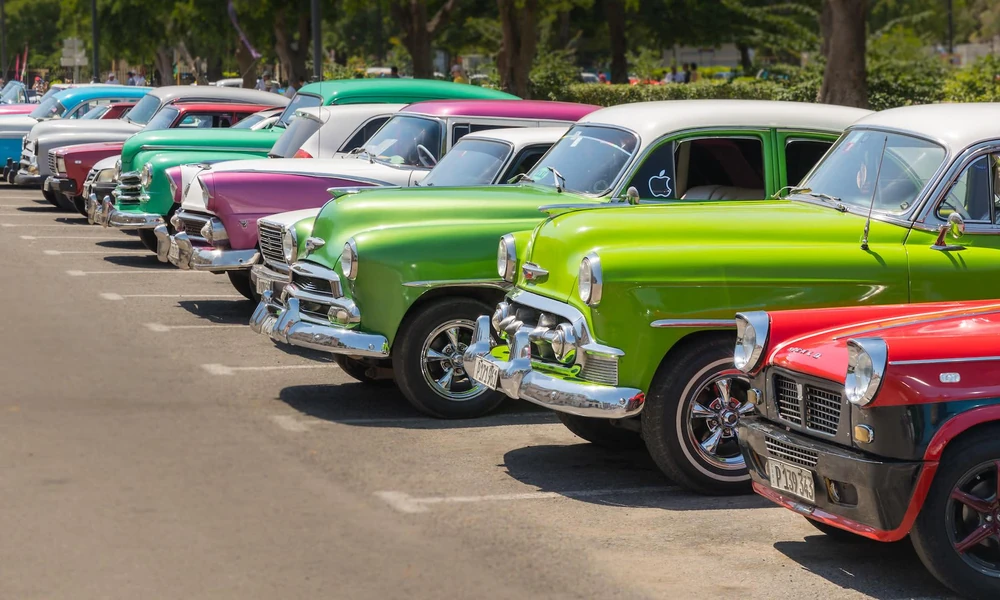 Vintage American classic cars displayed side by side outdoors.
