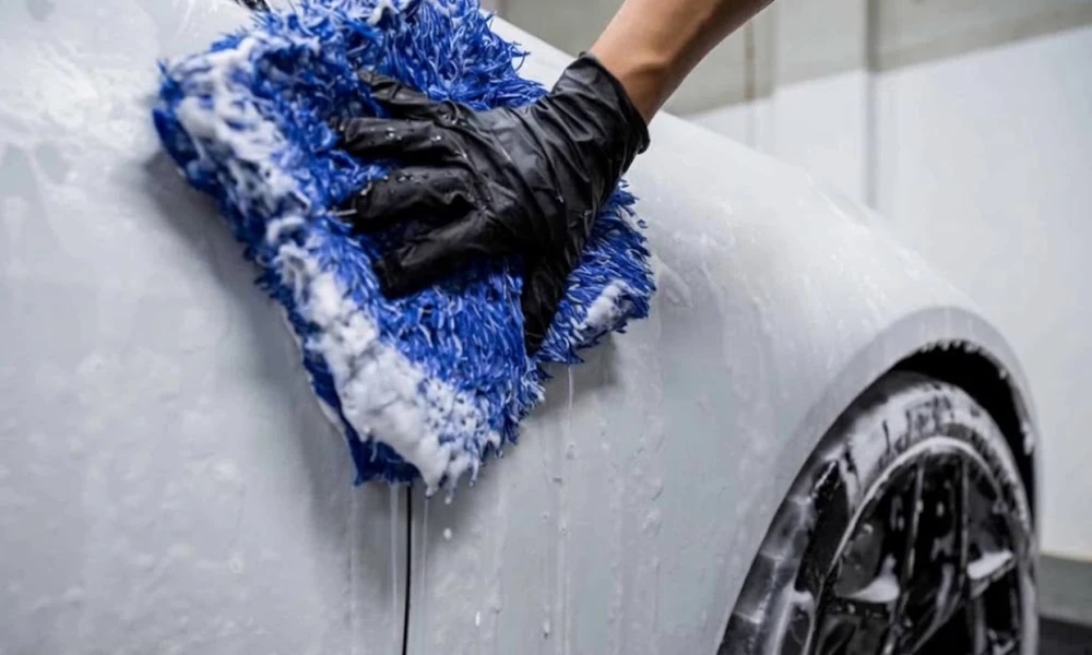Ceramic-coated car being washed with automotive shampoo and a microfiber mitt.