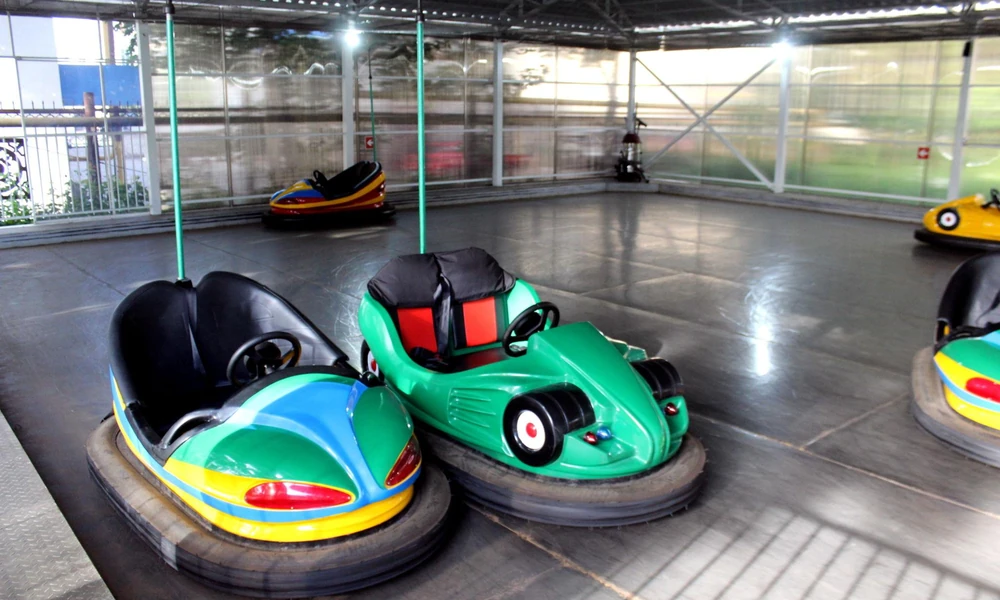 Traditional bumper car showing its overhead electrical contact pole and power grid.