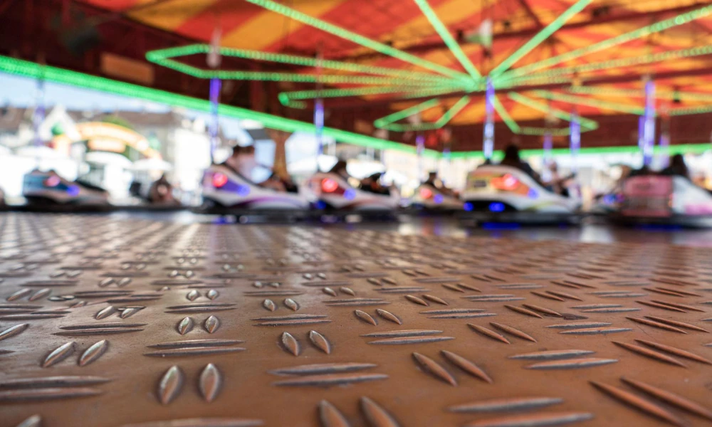 Electric bumper cars operating on a modern floor-powered amusement arena.