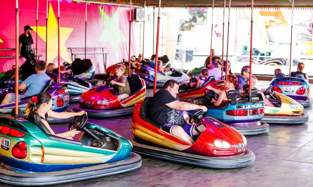 Classic traditional bumper cars arranged inside an amusement park arena.