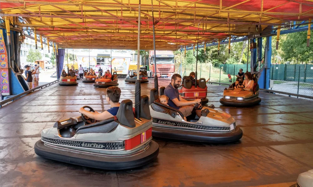 Outdoor bumper car attraction with colorful vehicles at an amusement park.