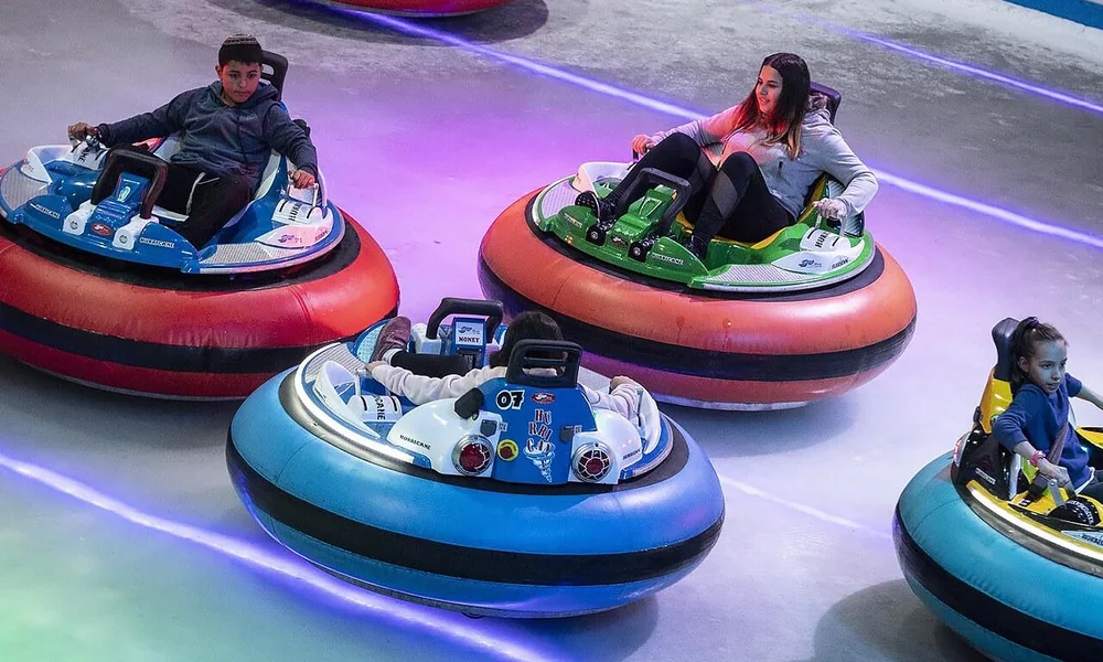 Inflatable bumper cars with soft protective outer rings inside an indoor arena.