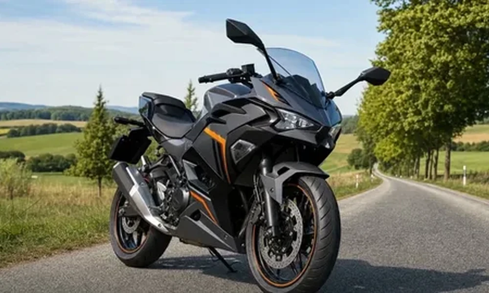 Black Kawasaki Ninja 500 sport motorcycle with orange accents parked on a country road with green trees and fields behind it