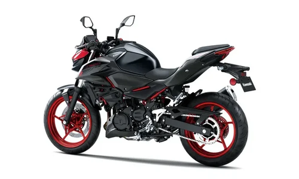 Black Kawasaki Z500 naked motorcycle with red wheels and red frame accents, rear three-quarter view on a white background