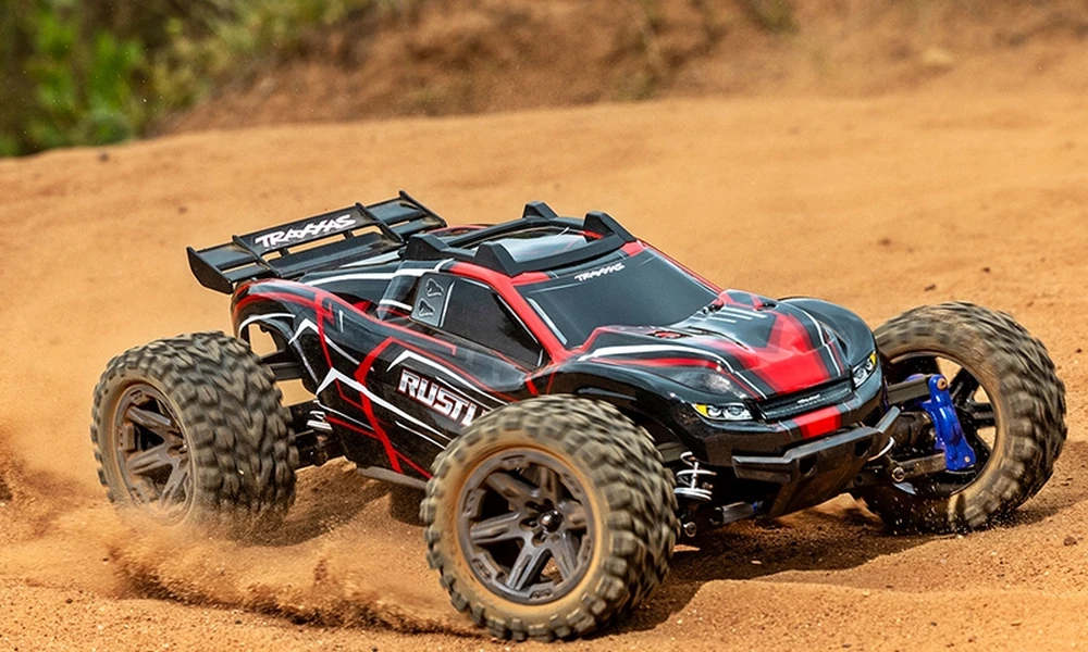 Traxxas Rustler stadium-style RC truck jumping on off-road terrain