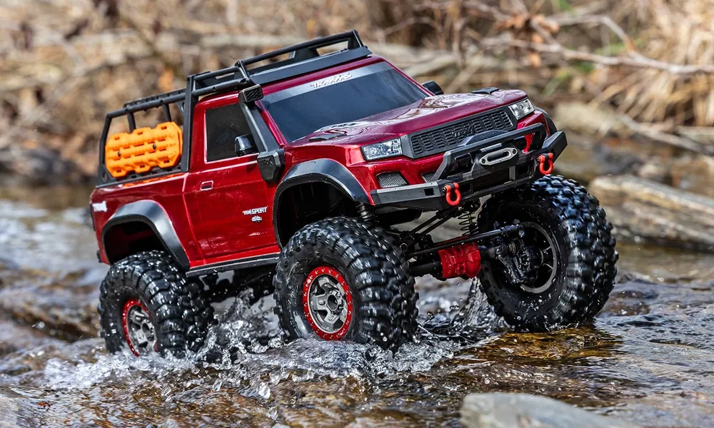 Traxxas TRX-4 RC trail truck climbing over rocks and roots