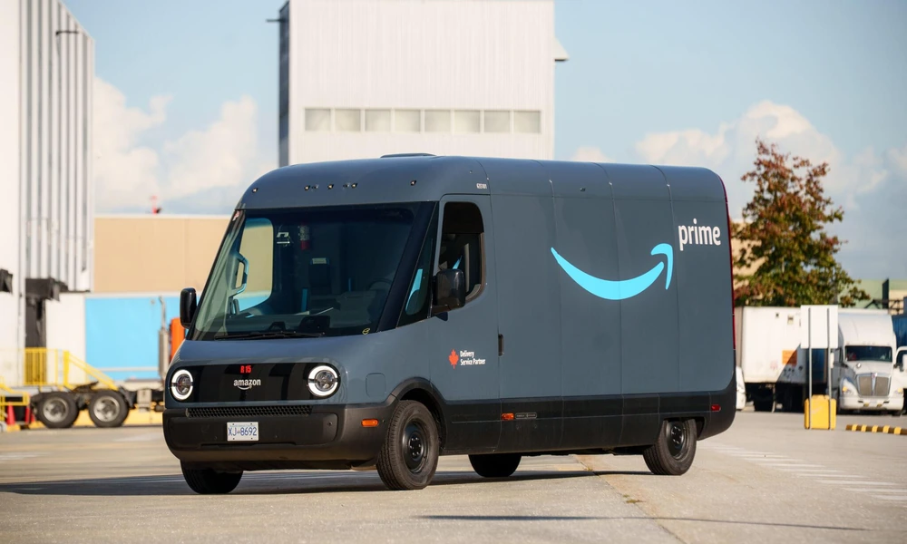 Rivian electric delivery van parked outside a commercial warehouse.