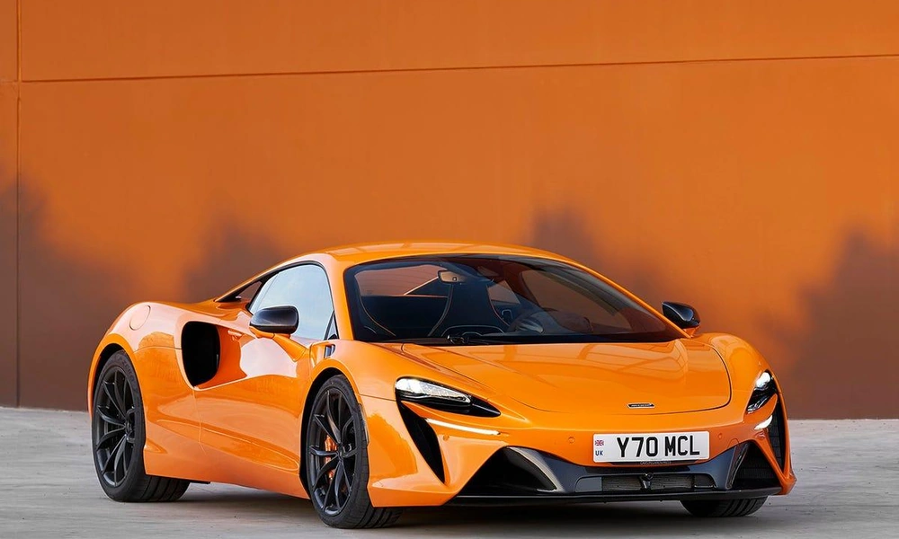 Orange McLaren Artura parked outdoors.