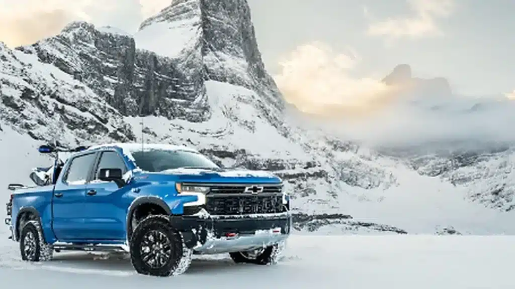 Pickup truck travelling through snowy winter conditions.